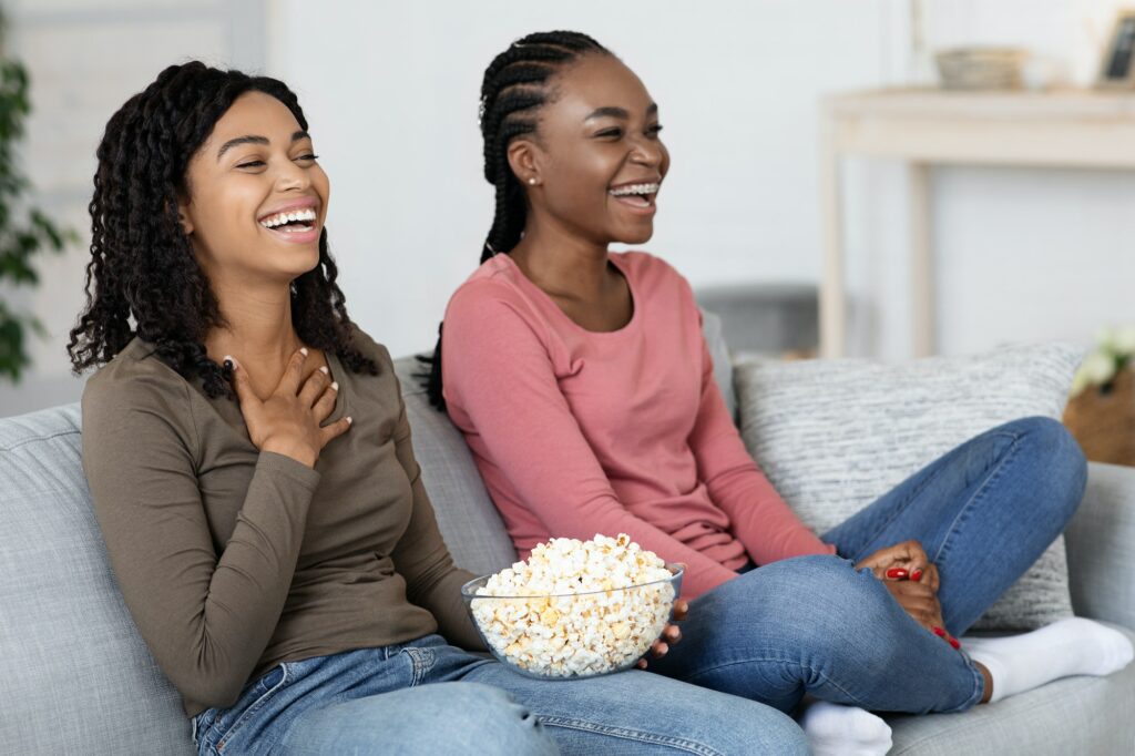 African american women watching comedy at home